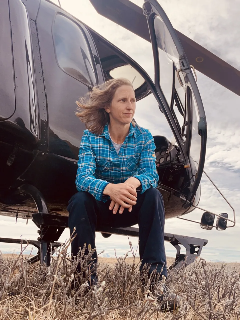 Jessica Meiris seated in the doorway of a helicopter